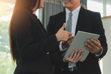 Business people talking and smiling content on tablet together, business concept