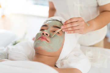 A female therapist doing Facial Spa/Treatment Add moisture to the skin with Asian woman lying on a bed in spa salon.