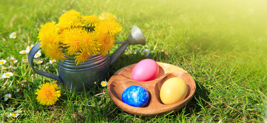 Fototapeta na wymiar Easter eggs and watering can with flowers. Easter background.