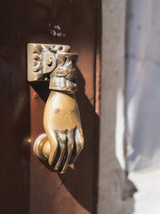 Fototapeta na wymiar Brown old metal door handle. form of a hand