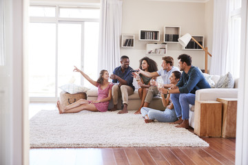 Group Of Friends Relaxing At Home Watching TV Together