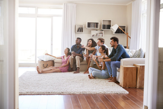 Group Of Friends Relaxing At Home Watching TV Together