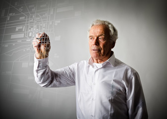 Old man is looking for a route on the city map.