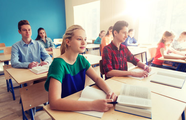 group of students with books at school lesson