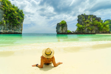 Fototapeta na wymiar Young woman relaxing on topical beach at Hong Island Krabi Thailand.