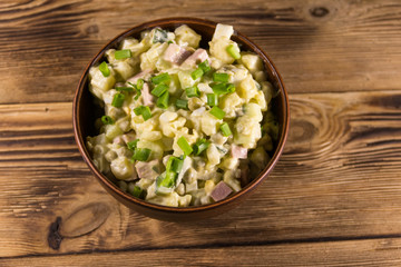 Traditional Russian festive salad Olivier on wooden table
