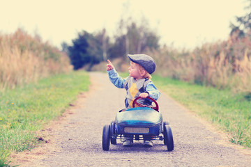 kleiner Junge im Tretauto