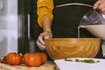 Woman preparing delicious pizza with healthy ingredients.