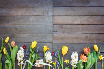 Spring flowers with a gift on vintage planks
