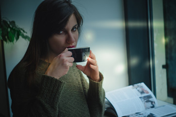 Fototapeta premium Girl drinking coffee / tea in cafe and enjoying the sunrise / sunset