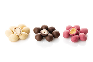 Heap of sugared almonds and hazelnuts dragees in chocolate isolated on white background