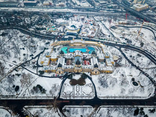 Fototapeta premium Budapest, Hungary - Aerial view of the famous Szechenyi Thermal bath from above in the snowy City Park at winter time