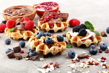 Belgian waffles with pomegranate and raspberries, homemade healthy breakfast with mint