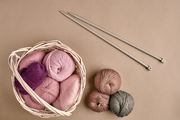 Yarn balls. Balls of colored yarn in a wicker dish. Yarn for knitting on a beige background....