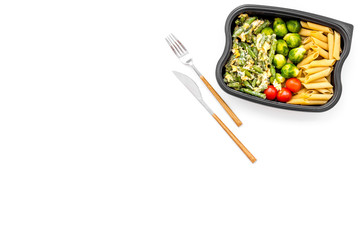 Healthy and hearty lunch for office worker. Vegetables Brussels sprout, cherry tomatoes, knock beans near pasta in plastic container on white background top view copy space