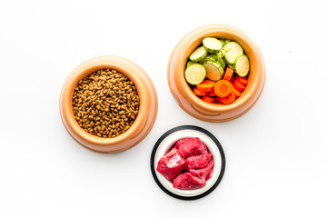 Ingredients for dry pet food. Meat and vegetables zucchini and carrot on white backgroud top view copy space