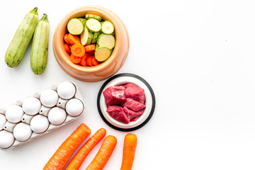 Ingredients on for pet food. Raw meat and vegetables on white backgroud top view copy space