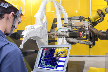 Industry 4.0 Robot concept .Engineers use laptop computers for machine maintenance, automation...
