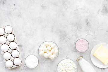 Natural farm products. Milk, cottage, eggs, cheese, yougurt on grey background top view copy space. Monochrome