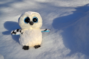 Cute owl toy on the snow outdoor.