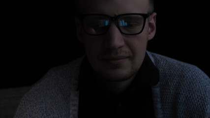 Obraz premium Man, face, with glasses, reflection, looking at graphics and work on the Internet, black background.