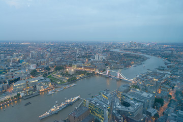 Fototapeta premium LONDON - SEPTEMBER 24, 2016: Aerial view of Tower Bridge and city skyline at night. The city attracts 30 million tourists annually