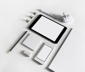 Photo of blank stationery and gadgets on paper background. Corporate identity template. Responsive design mockup.