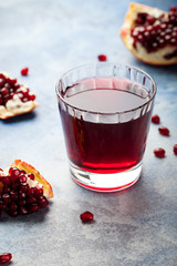 Pomegranate juice in a glass. Stone background.