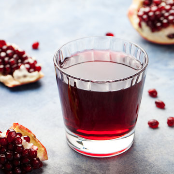 Pomegranate juice in a glass. Stone background.
