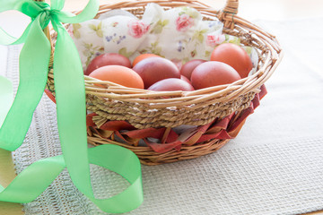Easter eggs in the basket of wooden boards