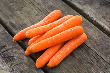 Fresh and ripe carrots on wooden background