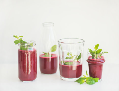 Fresh morning beetroot smoothie or juice in glasses with mint leaves, white background, copy space. Healthy vegan, vegetarian breakfast, seasonal detox, alcaline diet, weight loss food concept