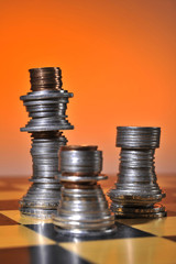 Schachfiguren. Münzen geformt und aufgestapelt wie Schachfiguren. Strategisches Spiel. König, Pferd, Bauer, Läufer Turm mit Geld dargestellt.  © Peter Frommenwiler
