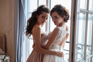Fototapeta premium Beautiful bride and bridesmaids in luxury dresses. Twins young women in wedding photosession