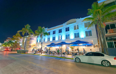 Obraz premium MIAMI - FEBRUARY 25, 2016: Tourists along Ocean Drive on a beautiful winter night. Miami Beach is a famous tourist attraction