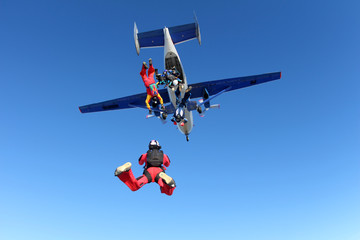 Skydivers are jumping out of a plane.