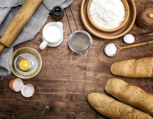 white wheat flour in a wooden bowl and baked baguettes