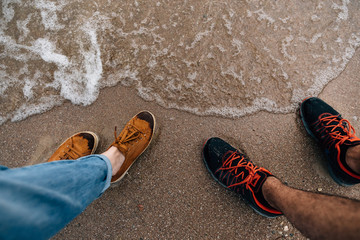 Naklejka premium feet on the sand near the water