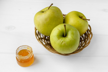 Small basket with fruits. Apples, lemons, carrot on the table. Jar of honey, bowl of oatmeal. Green tablecloth. Healthy eco lifestyle. Food blog illustrations. Cooking fruit salad. Pile of apples