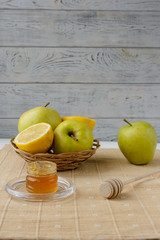 Small basket with fruits. Apples, lemons, carrot on the table. Jar of honey, bowl of oatmeal. Green tablecloth. Healthy eco lifestyle. Food blog illustrations. Cooking fruit salad. Pile of apples