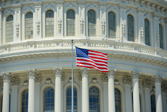 US National Flag in front of United State Capitol Building in Washington, District of Columbia, USA.