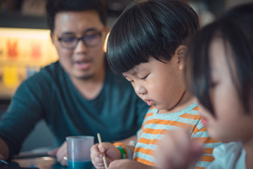 Father and son are painting.