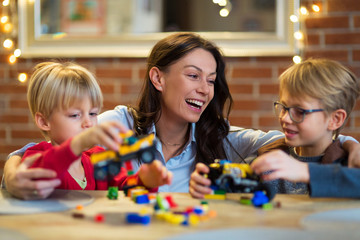 Fototapeta premium Mother and Children Playing with Blocks At Home 