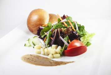Fresh green salad with small bread and corn