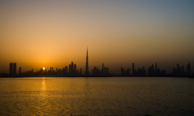 Fototapeta premium Słońce zachodzi za Dubajem.