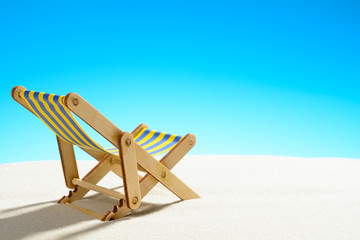 Sun lounger on the sandy beach and sky with copy space