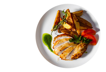 Grilled chicken breast with potato in a plate isolated on white background. with copy space. top view