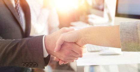 Obraz na płótnie Canvas businessman shaking hands with a business partner sitting near your desktop