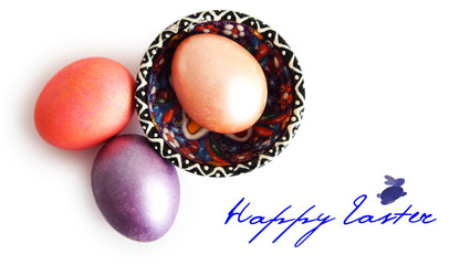 three eggs, color saucer, inscription of happy Easter on a white background.