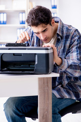 Obraz premium Hardware repairman repairing broken printer fax machine